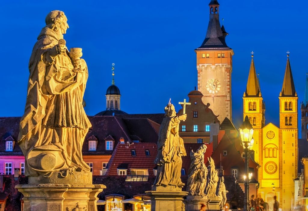 Stone statues of saints on a bridge in Würzburg, Bavaria, with the old city and cathedral in the background